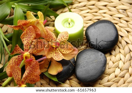 Spa concept Ã¢Â?Â? orchid and candles and green candle with leaves on woven mat