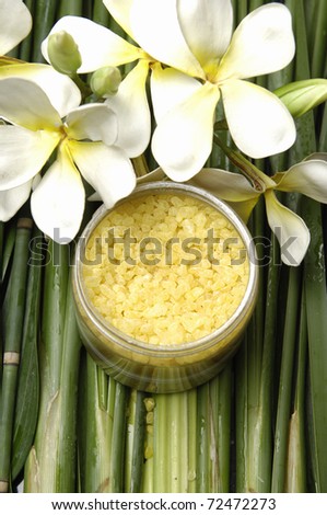 Sea salt bath in wooden bowl and white frangipani flower