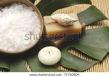 bowl of bath salt with candle and soap on pretty bamboo mat