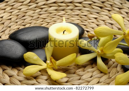 Spa theme- candle and zen stones with orchid on woven mat