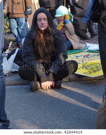 COPENHAGEN - DEC 12: Young woman takes a rest at the beginning of the demonstrations in Copenhagen during the climate conference on December 12, 2009