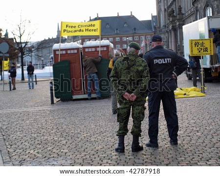 COPENHAGEN - DEC 12: The police and army keep a watchful eye on activists setting up their stand during the UN Conference on Climate Change on December 12, 2009 in Copenhagen.