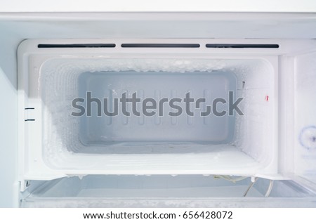 empty freezer of a refrigerator - Ice buildup on the inside of a freezer walls.