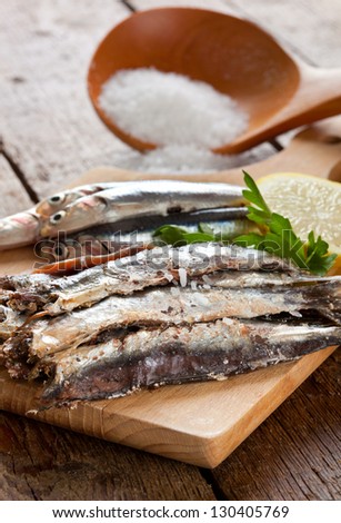 Marinated anchovies on wooden table
