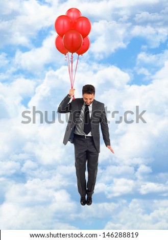 Businessman flying in blue cloudy sky with red balloons