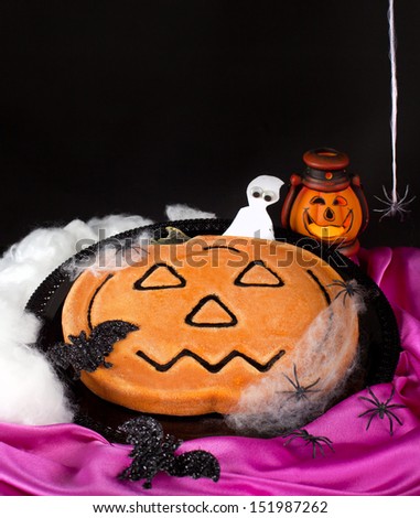 Pumpkin pie with spiders on black background