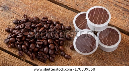 Coffee beans with pods on wooden table.
