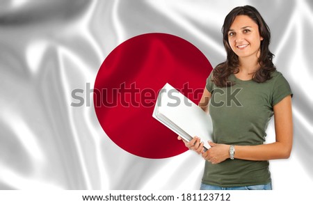 Young female student smiling over Japanese flag