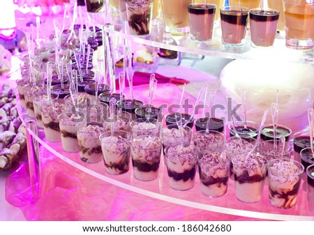 Dessert buffet during a wedding with purple lights.