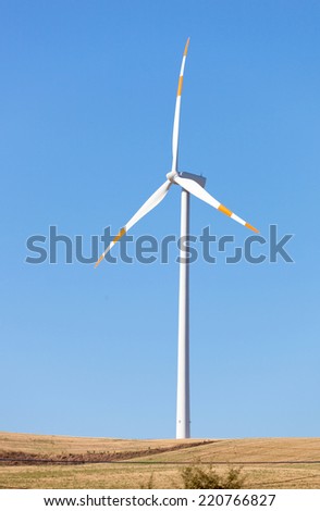 Wind turbines in operation in the summer with blue sky.