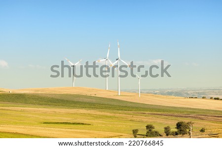 Wind turbines in operation in the summer with blue sky.