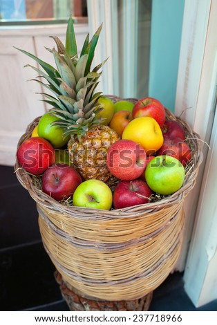 Basket of fruit, pineapple and apples.