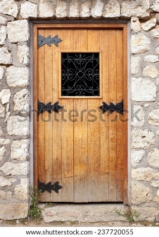 Old wooden door in the stone wall.