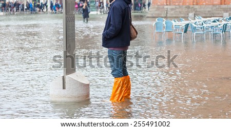 Close Up of legs with boots due to the high water. This flood happens when there is high tide in Venice, Italy.