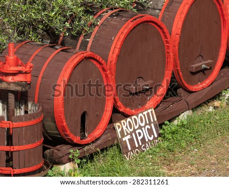 Wine barrels with wine press in outdoor field, Tuscany.