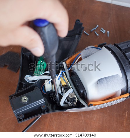 Vacuum cleaner disassembled for repair malfunctioning on work table