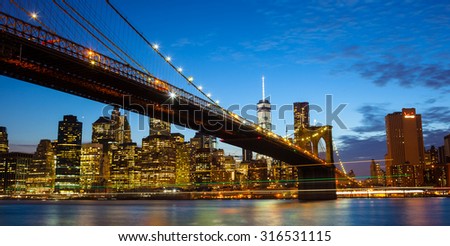 Spectacular view of Manhattan by night from Brooklyn with luminous trail of boats, New York City