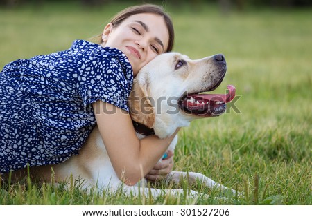 Portrait of a woman with her beautiful dog lying outdoors. Training the dog