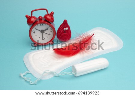 Medical conception photo. Red dreamy smile crochet blood drop, daily and menstrual pad and tampon. Woman critical days, gynecological menstruation cycle. Menstruation sanitary woman hygiene