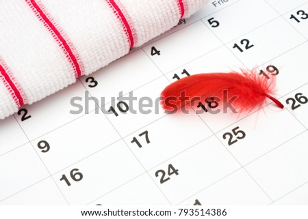 Feminine hygiene products, blood period calendar and terry towel with red feather. Menstruation period pain protection in monthlies, gynecology concept
