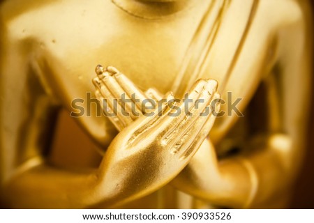 Hands of buddha statue touching the heart on chest level.