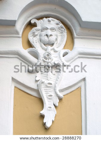 detail of fence, lion, holding flower in mouth