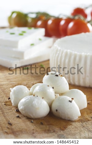fresh raw white soft greek feta cheese round and slices on wooden plate isolated over white background