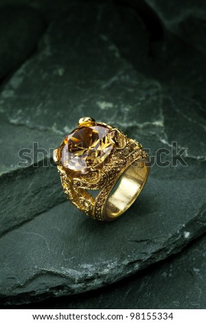 Golden finger ring with yellow precious stone
