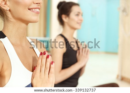 Happy and healthy. Cropped horizontal portrait of two ladies meditating with hands in Namaste gesture