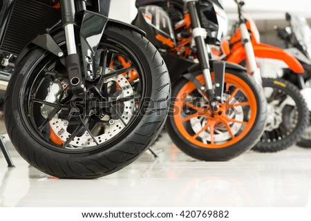 Riders will love. Cropped shot of the wheels of motorbikes standing in the line at the motorcycle salon