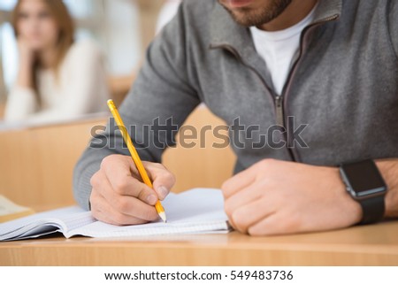 Modern accessory. Cropped close up of a man wearing smart watch writing in his notebook while studying education student project working business technology gadget modern smart watch concept