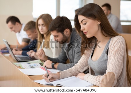 Educational process. Group of young people studying in university sitting in auditorium during lecture education students college university studying youth campus friendship teenager teens concept