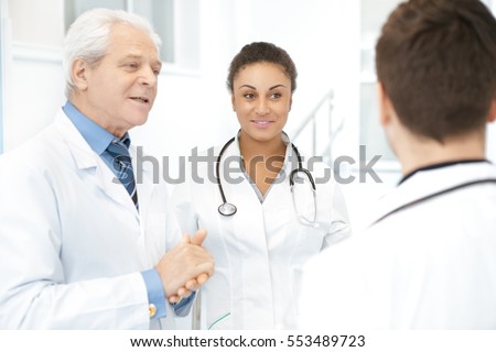 Before the shift starts. Shot of a diverse team of experienced doctors having a chat at the hospital senior male doctor advising his younger colleagues on treatment medicine people profession concept