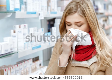Seasonal health issues. Close up shot of a young woman sneezing in a paper napkin while shopping at the drugstore copyspace illness buying medications shopping customer client cold concept