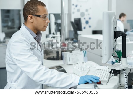 The best lab. Handsome young African male laboratory technician using a computer working in the lab medicine research analyzer clinical chemistry immunochemistry efficiency experience digital concept