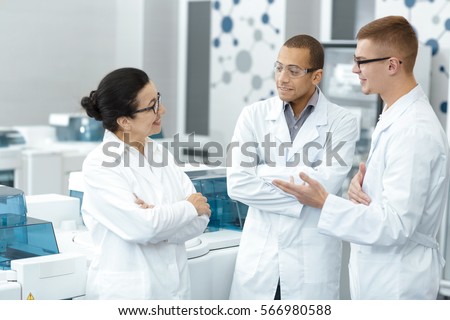 Lab team. Multiethnic group of laboratory scientists discussing their research at the lab teamwork technician specialist profession job colleagues medicine chemists biologists team study communication