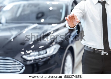Passing car keys. Cropped closeup of a car dealer holding out car keys to the camera copyspace car dealership salon manager salesman selling buying giving owner profession purchase vehicle concept