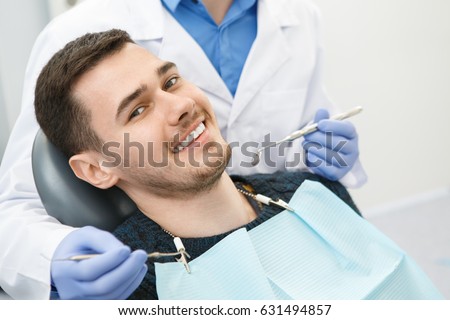 Shot of a cheerful handsome man smiling to the camera sitting in a dental chair his dentist preparing for dental checkup on the background copyspace health medicine people dentistry doctor curing