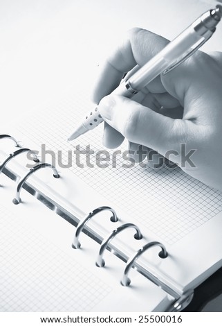 hand holding ball pen and agenda