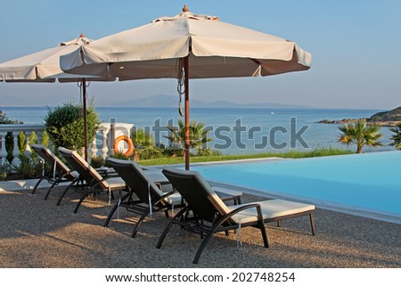 Row of pool chairs and umbrellas. Luxury Mediterranean hotel