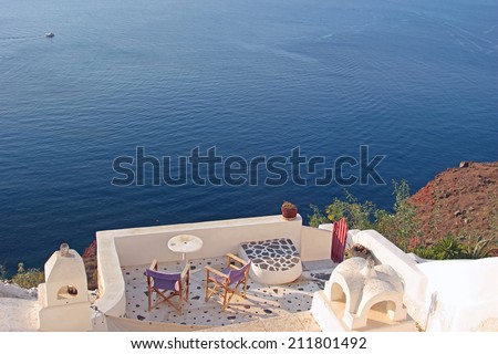 Terrace with deck chairs. View to the caldera in Santorini island, Greece