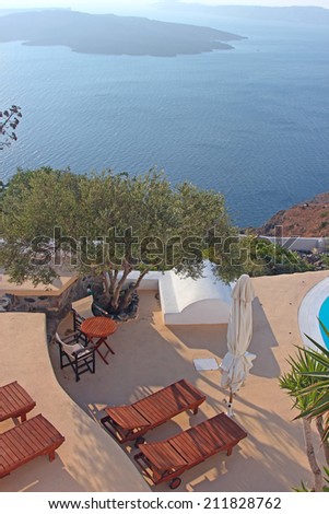 Terrace with deck chairs. View to the caldera in Santorini island, Greece