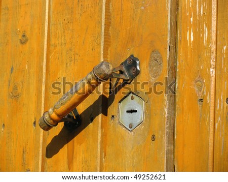 Old wooden weathered door with doorhandle and keyhole