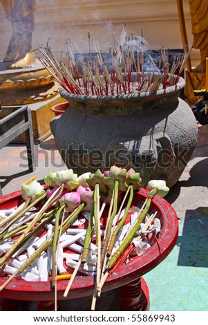 Offering in a Buddhist temple - lotus flowers and incense sticks