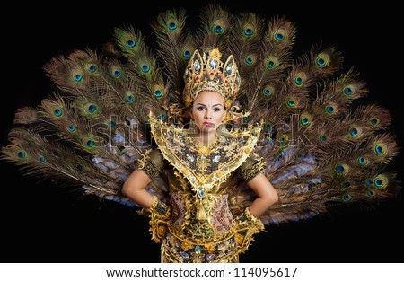 dancer in a golden dress with peacock feathers