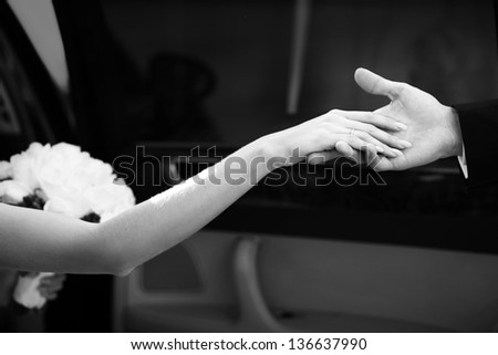 bride\'s hand and the hand of the groom while getting out of the car
