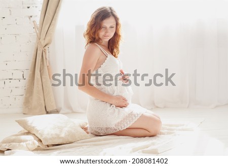 beautiful pregnant woman in white clothes in the bedroom interior