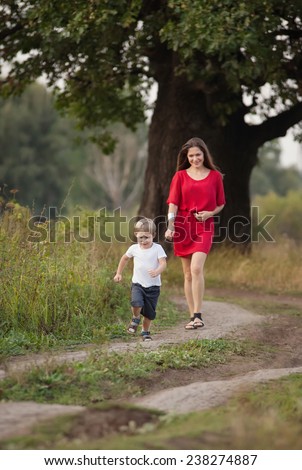 mother and son walking by the road in countryside