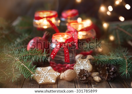 Christmas decorations. Candles in glass jars with fir  and gingerbread cookies
