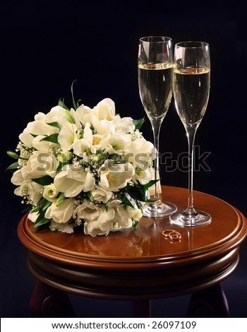 stock photo Two wine glasses of champagne and wedding bouquet on a black 